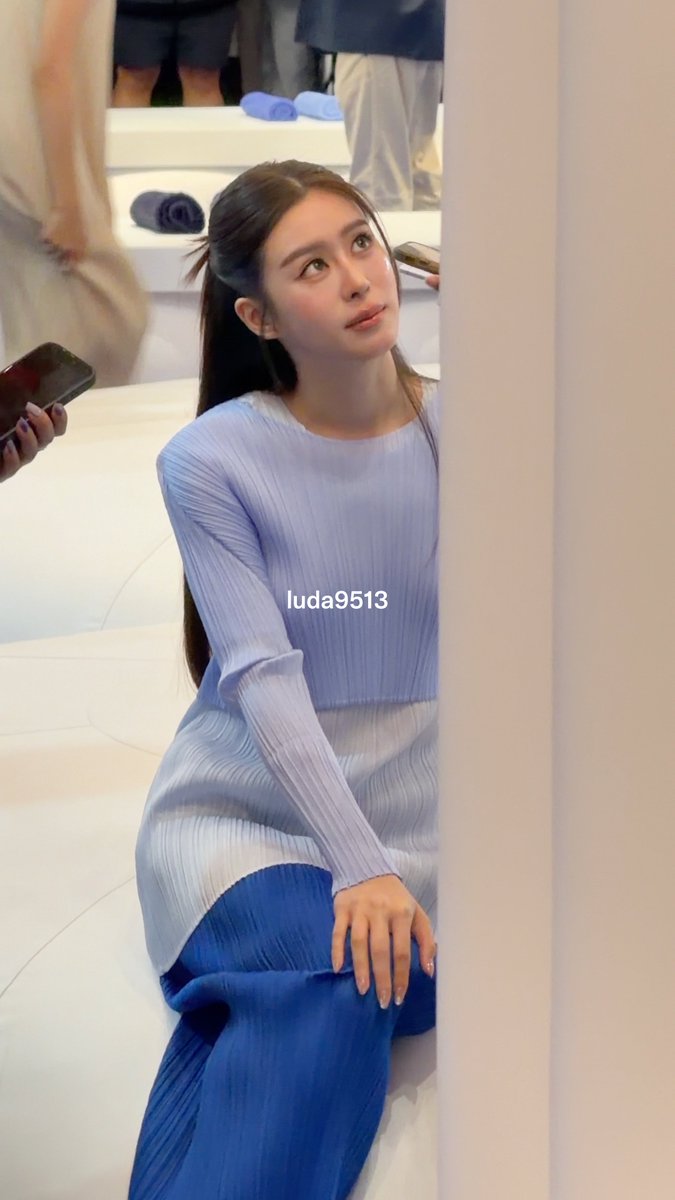 A young woman with long dark hair, wearing a light blue ribbed long-sleeve top and matching blue skirt, sits looking upward, with the text "luda9513" overlaid on the image.