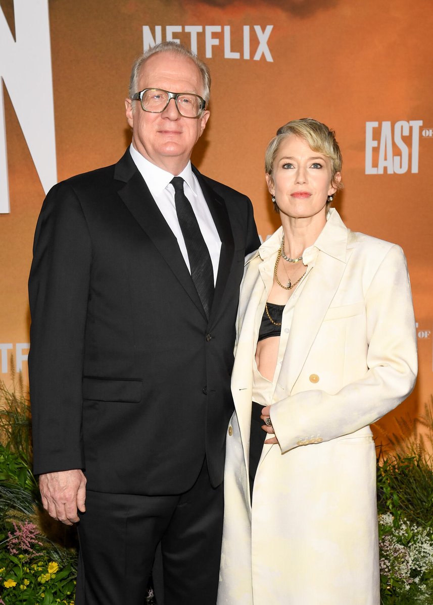 celeb124's tweet photo. Carrie Coon hit the East of Eden premiere at The Plaza Hotel in New York City in an open cream double-breasted coat over a black bandeau and high-waisted black trousers. Layered gold and beaded necklaces finished the Netflix carpet look beside husband Tracy Letts. https://t.co/wxP5IqlsUH
