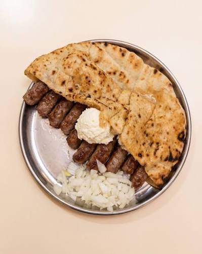 ismailvefa's tweet photo. Yarın için Saraybosna'da cevapi yemek isteyenlere bir not:

Saraybosna'da cevapi yani Bosna usulü köfte genelde 5'li, 10'lu ve 15'li porsiyonlar halinde satılıyor. 
Ancak en çok 10'lu yani Boşnakların ifadesiyle "desetka" sipariş ediliyor.  

Bosna Hersek'in efsane futbolcusu Edin Dzeko'nun milli takıma veda edecek olması nedeniyle 10'lu cevapilere bir süreliğine güncelleme geldi.   

Dzeko'nun milli takımda giydiği 11 numaralı formanın hatırına somunun içinde 11 adet köfte gelecek..