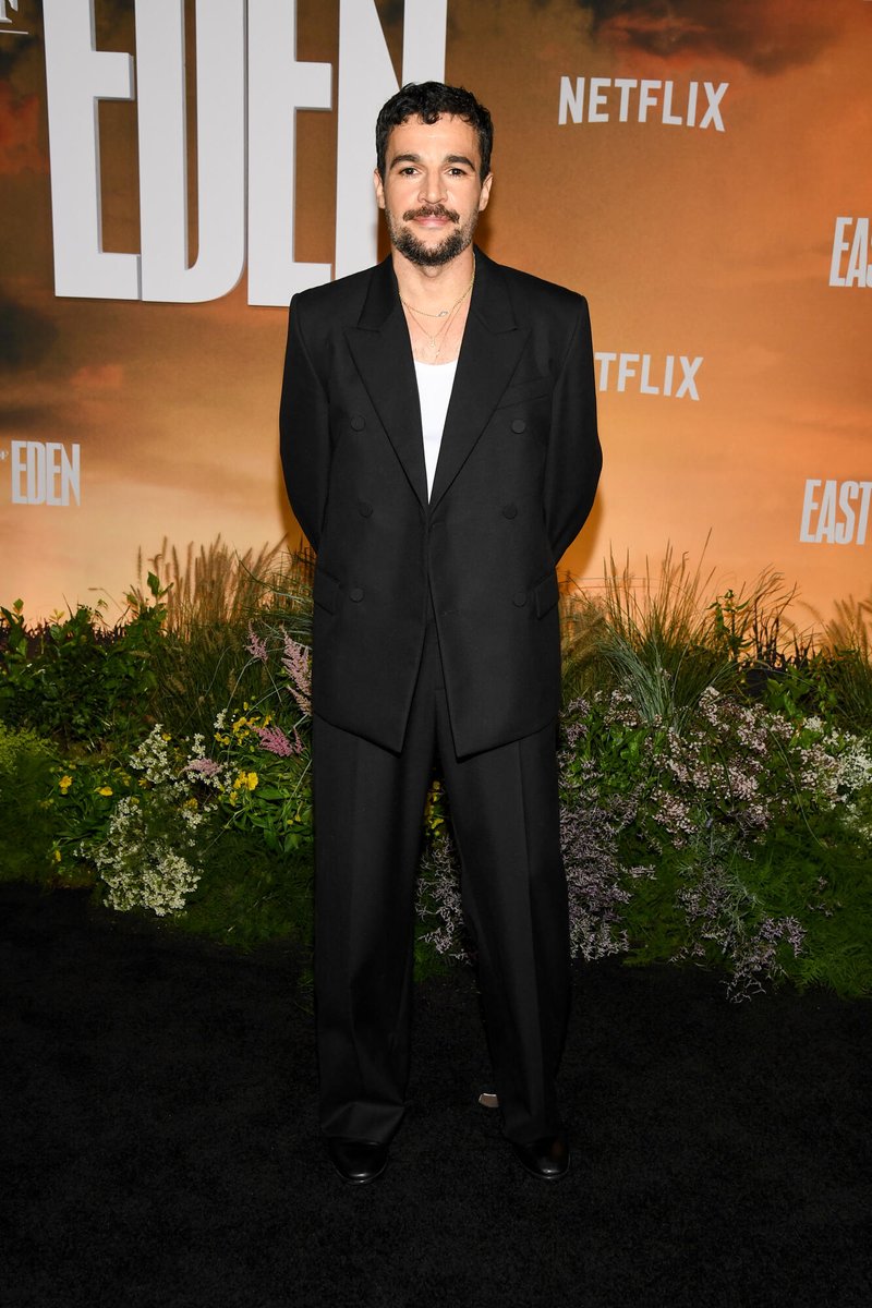 celeb124's tweet photo. Christopher Abbott hit the East of Eden premiere at The Plaza Hotel in New York City in a black double-breasted suit worn open over a white tank and layered gold necklaces. Wide-leg black trousers and polished dress shoes finished the Netflix carpet look. https://t.co/q3npBUB9QQ