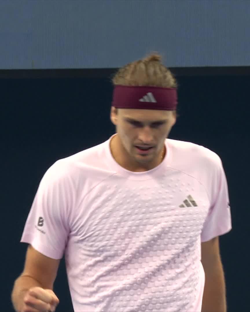 Alexander Zverev, wearing a pink Adidas shirt and matching headband, walks on the court at the China Open after extending his winning streak against Norrie with a 7-6, 6-4 victory.