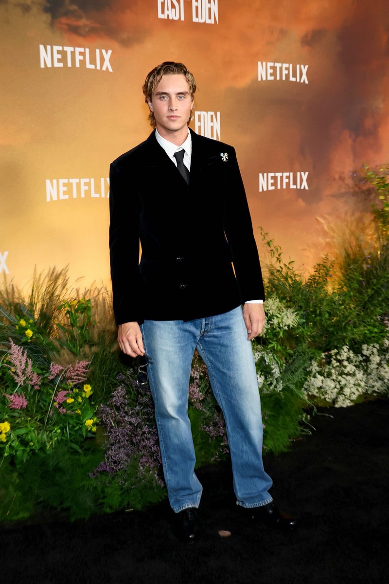 celeb124's tweet photo. Joseph Zada hit the East of Eden premiere at The Plaza Hotel in New York City in a custom Louis Vuitton black velvet double-breasted blazer with a floral monogram brooch, white shirt, black tie, and light-wash jeans. Blue-tint sunglasses finished the Netflix carpet look. https://t.co/5F2pm7ADDu