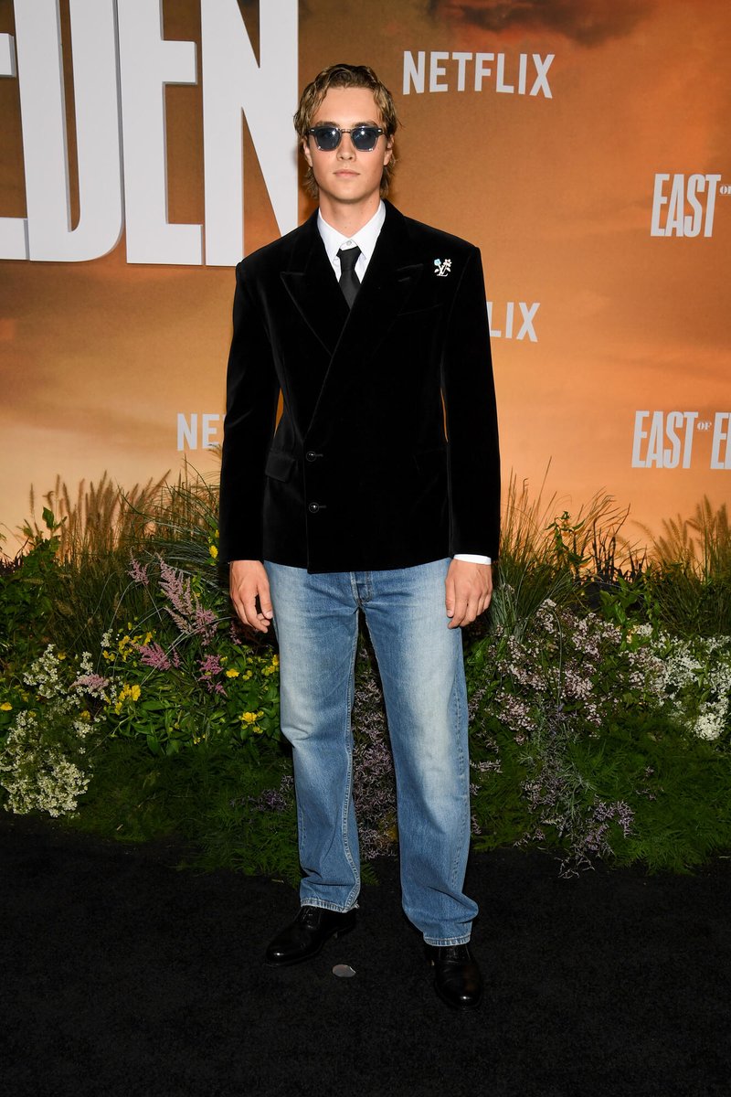 celeb124's tweet photo. Joseph Zada hit the East of Eden premiere at The Plaza Hotel in New York City in a custom Louis Vuitton black velvet double-breasted blazer with a floral monogram brooch, white shirt, black tie, and light-wash jeans. Blue-tint sunglasses finished the Netflix carpet look. https://t.co/5F2pm7ADDu