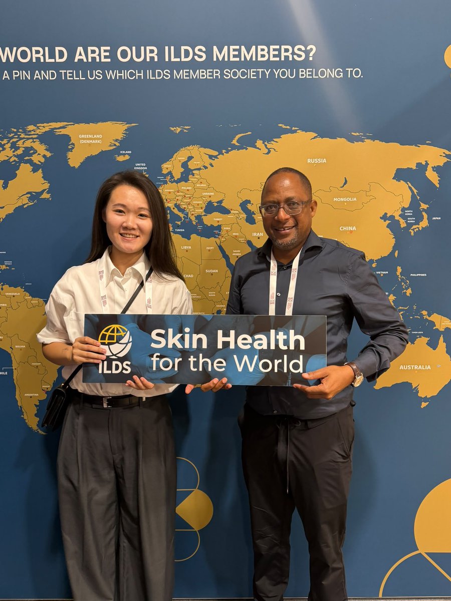 IFDerm's tweet photo. A familiar face at #EADV2026! 🌍 Our Programmes and Grants Lead, Jianing Li, caught up with Prof Daudi Mavura, Principal of the @RDTCTZ in Moshi, Tanzania, at the ILDS booth - and of course we had to get a photo in front of our global member map! https://t.co/BoRcpCFbpv