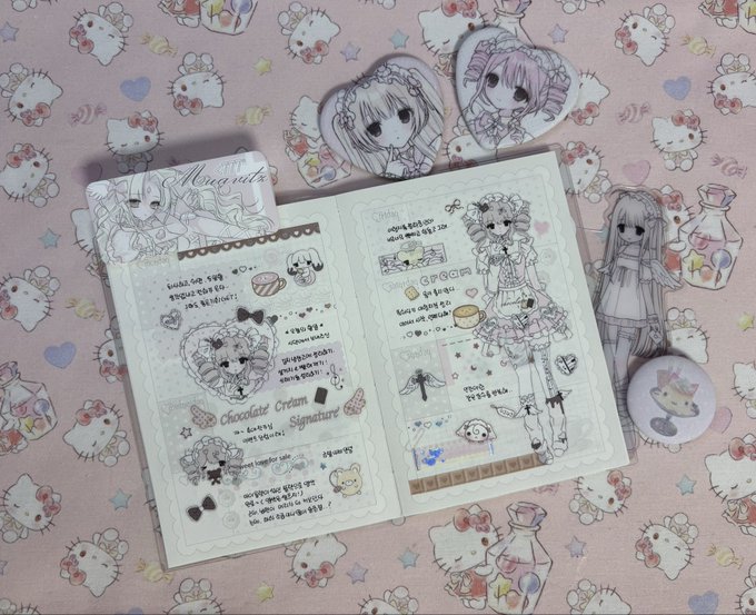 A stationery journal titled 'Mona eats' and 'Chocolate Cream Signature' sits on a Hello Kitty-patterned surface, featuring hand-drawn character illustrations and decorative elements.