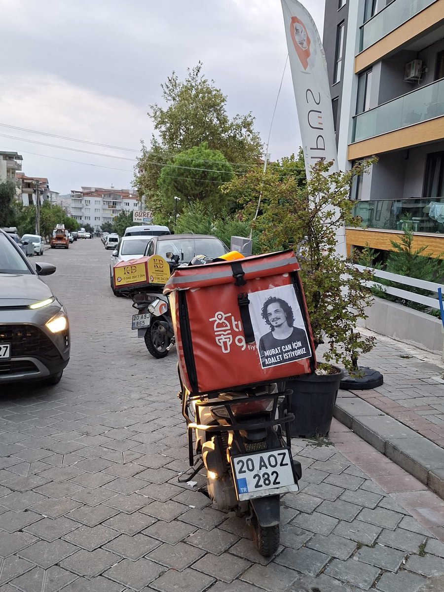 birgaripgeveze's tweet photo. Bazen bir fotoğraf görürsünüz… Ben bugünlerde yollarda Murat Can’ın fotoğrafını görüyorum. Onu hiç tanımayan moto kuryelerin, Murat Can’ın fotoğrafıyla yollara çıktığını görüyorum. Ve her gördüğümde boğazım düğümleniyor.

Şimdi onun fotoğrafını taşıyan her motoru gördüğümde, sanki Murat Can yeniden yollarda… Bir kurye geçiyor yanımdan; üzerinde Murat Can’ın fotoğrafı. Ben onu tanımıyorum, o da Murat Can’ı hiç tanımadı belki.

Ama aynı yolu biliyor. Aynı riski biliyor. Aynı yağmuru, aynı soğuğu, aynı trafiği biliyor. Ve belki de bu yüzden Murat Can’ın hikayesini kendi hikayesine yakın hissediyor.

Ben her fotoğrafını gördüğümde hem ağlıyorum hem de içimde tarifsiz bir güç hissediyorum.

Fotoğrafını taşıyan, adını yaşatan, hikayesini sahiplenen tüm arkadaşlarıma…

İyi ki varsınız. İyi ki Murat Can’ı yalnız bırakmıyorsunuz. İyi ki onun adını yollarda yaşatıyorsunuz.

Sadece bedenin yok ama ruhun hep bizimle güzel çocuk…