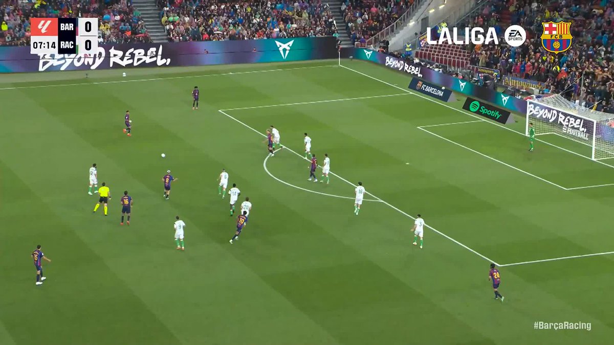 A La Liga match between Barcelona (BAR) and Racing (RAC) is shown at the 07:14 mark, tied 0-0, with Barcelona players in their iconic blue and red kits attacking the goal as Racing's defense attempts to block them. The image relates to the post by capturing the early moments of a match where João Cancelo would later score what would become the best goal of September in La Liga.