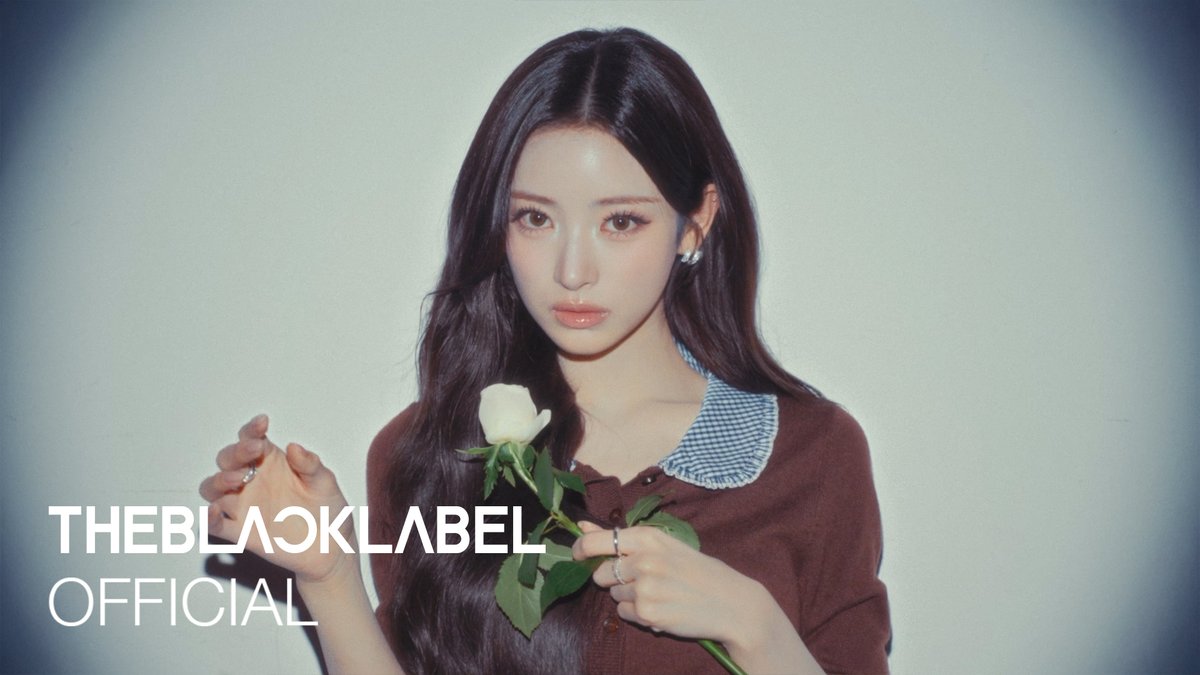 A promotional photo of a young woman with long dark hair holding a white rose, with the text 'THEBLACKLABEL OFFICIAL' overlaid on the image.