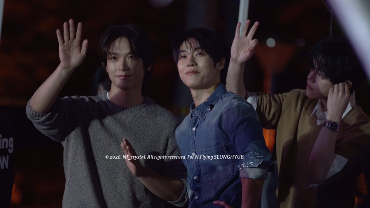 Three members of ENHYPEN wave and smile at fans before taking the stage at the Jang-an University Festival, as indicated by the watermark text "© 2026. NF crystal. All rights reserved. For N.Flying SEUNGHYUB." overlaid on the image.