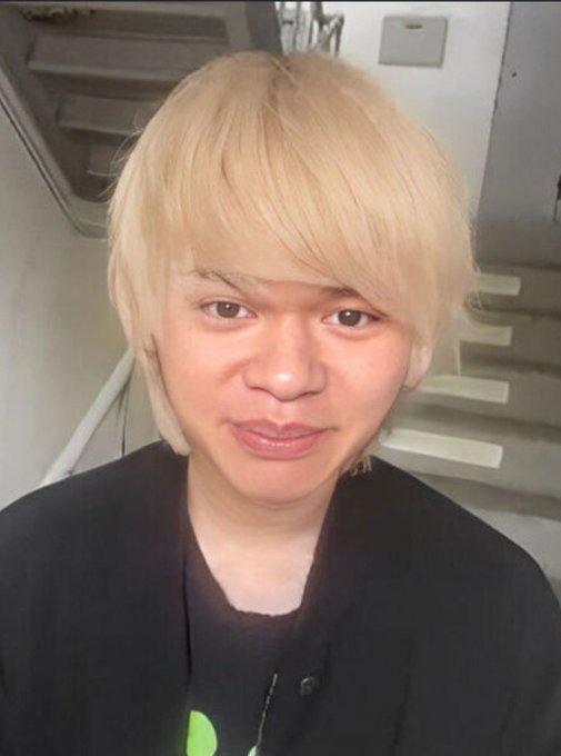 A blonde-haired person in a black cardigan poses for a close-up selfie, with their appearance aligning with the "造船太郎" (Shipbuilder Taro) character referenced in the post's contrasting captions about hitting the jackpot versus drowning in drugs.