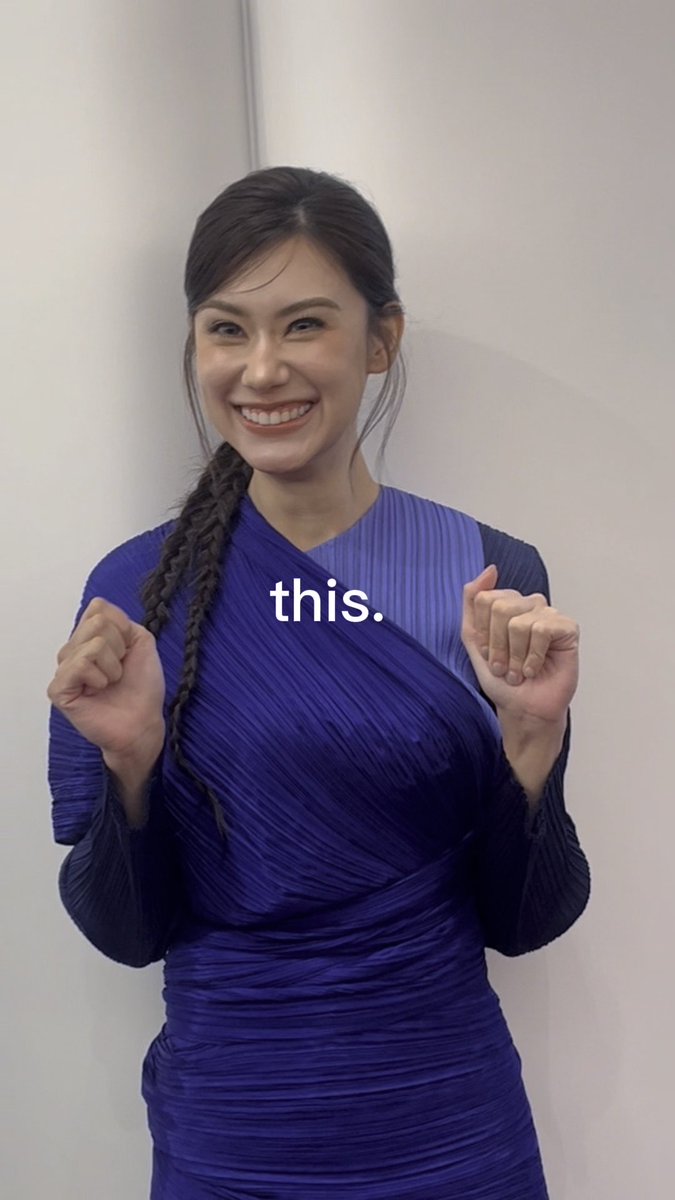 A smiling woman with a long braid wearing a blue pleated dress, with the text 'this.' overlaid on the screen.
