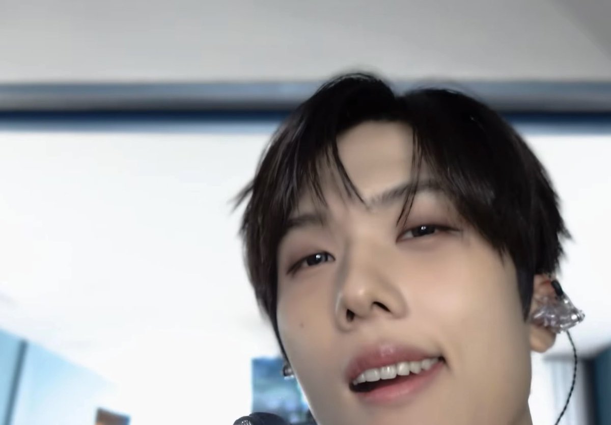 Jisung holds the camera close with a playful, slightly disappointed expression as he tries to get Jaemin's attention, but Jaemin has already walked past, unaware. The bright indoor setting and Jaemin's in-ear monitor suggest this is a behind-the-scenes moment during a music show or broadcast preparation.
