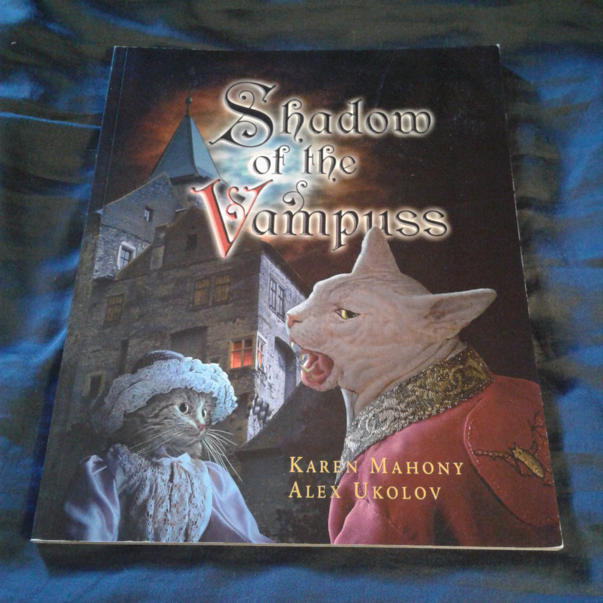 JamesGChampagne's tweet photo. Currently Reading: SHADOW OF THE VAMPUSS by Karen Mahony (writer) and Alex Ukolov (illustrator) 

This is yet another one of those cat-themed books I've had lying around for years (in this case, 2005, the year it was published) that I'm finally getting around to officially reading