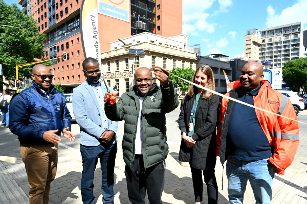 MyJRA's tweet photo. [OFFICIALLY OPEN] Ward 60 Councillor Sihle Nguse, Coj leadership, and project partners cut the ribbon at the intersection of Jorissen St &amp; Station St to mark the launch of October Transport Month 2026 and upgraded traffic signal infrastructure. 📸 #TransportMonth #JoburgRoads https://t.co/LbFh8Nmtgc