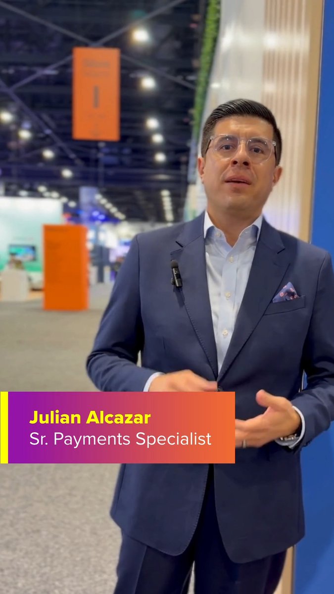 A man in a suit speaking at a conference, identified by an on-screen graphic as 'Julian Alcazar, Sr. Payments Specialist'.