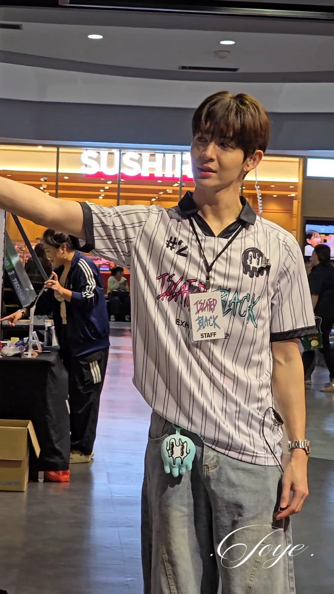 A young man wearing a striped staff jersey with 'Issa Back Staff' text and number '#42' at what appears to be a sushi restaurant, with 'Jaye' watermark visible.