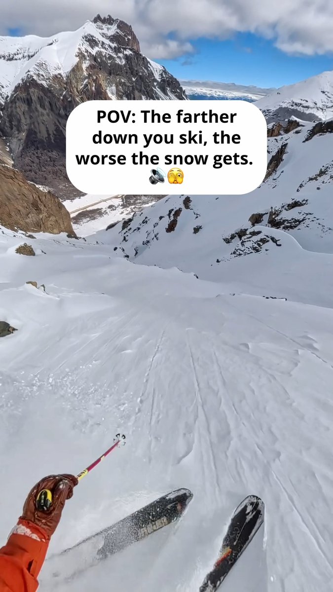 A first-person POV photo of a skier looking down a snowy mountain slope with ski poles visible, accompanied by an overlaid message: 'POV: The farther down you ski, the worse the snow gets.', followed by helmet and monkey emojis.