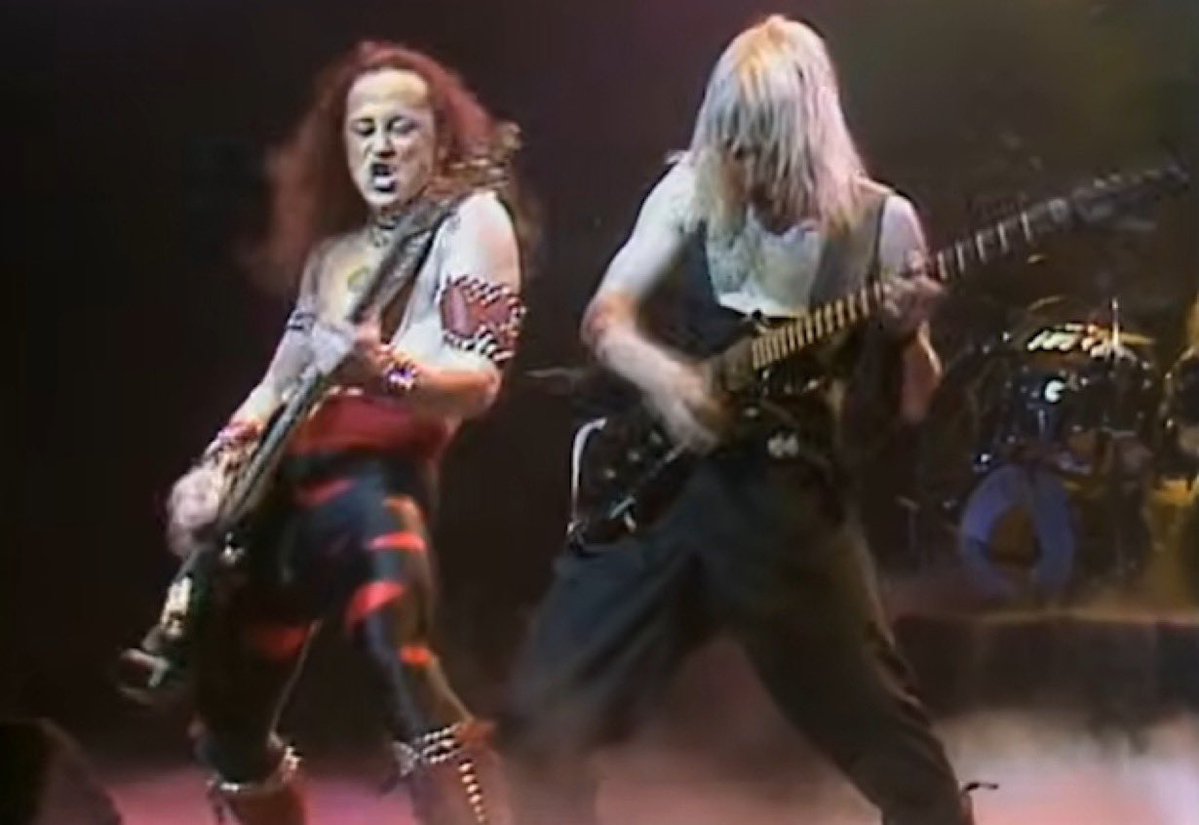 Sin23Ou's tweet photo. VENOMのオリジナル・ギタリスト、ジェフ・“マンタス”・ダンが、今週63歳で亡くなった偉大なるベーシスト兼ボーカリスト、コンラッド・"クロノス" ・ラントを追悼しました…マンタスはソーシャルメディアに次のように綴っています。

「みんなからの圧倒的な感謝と哀悼の意に、心からのお礼を。彼にはそれだけ���敬意が捧げられるべきだと、私も思うよ。

私自身、そして今日話をしたアバドン（VENOMのオリジナル・ドラマー、アントニー・ブレイ）を代表して言わせてもらえば、このバンドには波乱に満ちた歴史があったが、結局のところ、何か特別なものを始め、メタルの方向性やムーブメント、そしてその歴史そのものを変えたのは、私たち3人だったのだ。

私たちは2日前に��の知らせを受けていたが、当然ながらコンラッドの家族の同意や意向がない限り、誰にも何も言える立場にはなく、私たちはその意向を尊重していた。

こうした時に思い出すのは、初期の頃の友情だ。"一人は皆のために、皆は一人のために" という精神、反骨心、そして受け入れられるかどうかはさておき、他とは全く違う存在になろうとする強烈な衝動。

今でも、3人でただふざけ合って笑い転げている初期の映像が手元に残っているよ。私たちのユーモアのセンスは、独特なものだったからね。

数え切れないほどのメッセージをありがとう。先ほども言った通り、バンドの歴史、数々の口論や罵り合い、浮き沈み、そして機能不全とも言える状態……そういったことはあったにせよ、やはり彼の訃報はこたえるよ…。

安らかに。Rest in Power。コンラッド・クロノス・ラント」