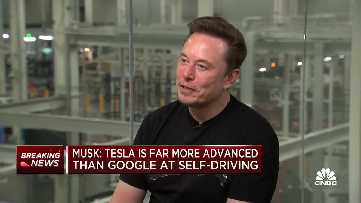 A CNBC breaking news screenshot of Elon Musk in a black t-shirt being interviewed in an industrial setting, with the headline 'MUSK: TESLA IS FAR MORE ADVANCED THAN GOOGLE AT SELF-DRIVING'.