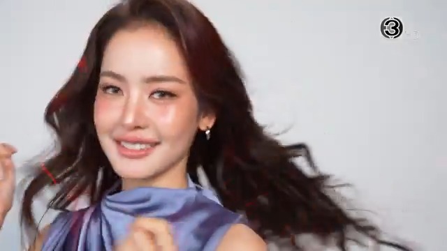 A smiling young woman with long dark hair, wearing a lavender-blue blouse, poses against a light background with what appears to be a logo in the upper right corner. The image, which resembles a promotional or calendar-style portrait, relates to the post's anticipation of a 2027 calendar release around New Year, suggesting this could be a featured model for such a calendar.