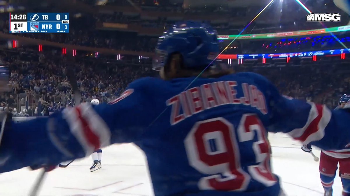 Rangers player Mika Zibanejad (#93) celebrates on the ice after scoring the team's first goal, with the scoreboard showing Tampa Bay (TB) and NY Rangers (NYR) tied 0-0 with 14:26 remaining in the 1st period, while the MSG network logo appears in the corner.