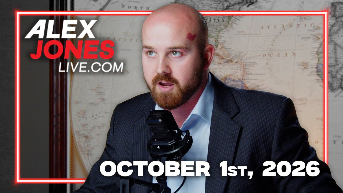 A bald, bearded man in a pinstripe suit speaks into a microphone in front of a world map, with a red heart sticker on his forehead. The image is branded with "ALEX JONES LIVE.COM" in the corner and dated "OCTOBER 1ST, 2026" at the bottom, promoting the Thursday Transmission episode covering unrest in France, Ukraine-Russia strikes, and James Fishback's 1776 framework discussion.