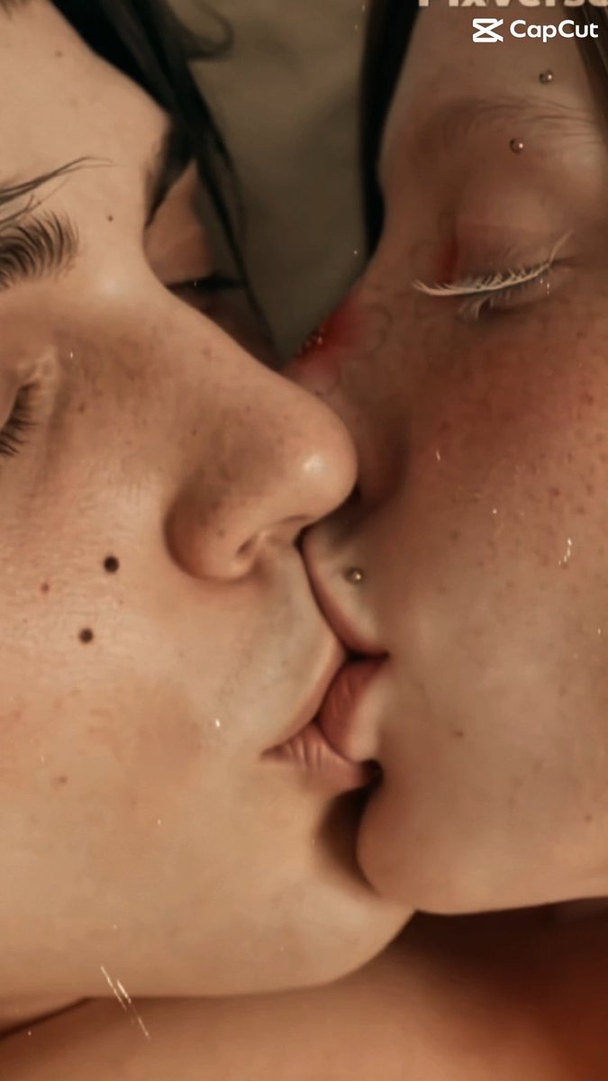 An extreme close-up, intimate photo of two faces kissing, showing visible piercings and freckles, with a CapCut watermark in the corner.