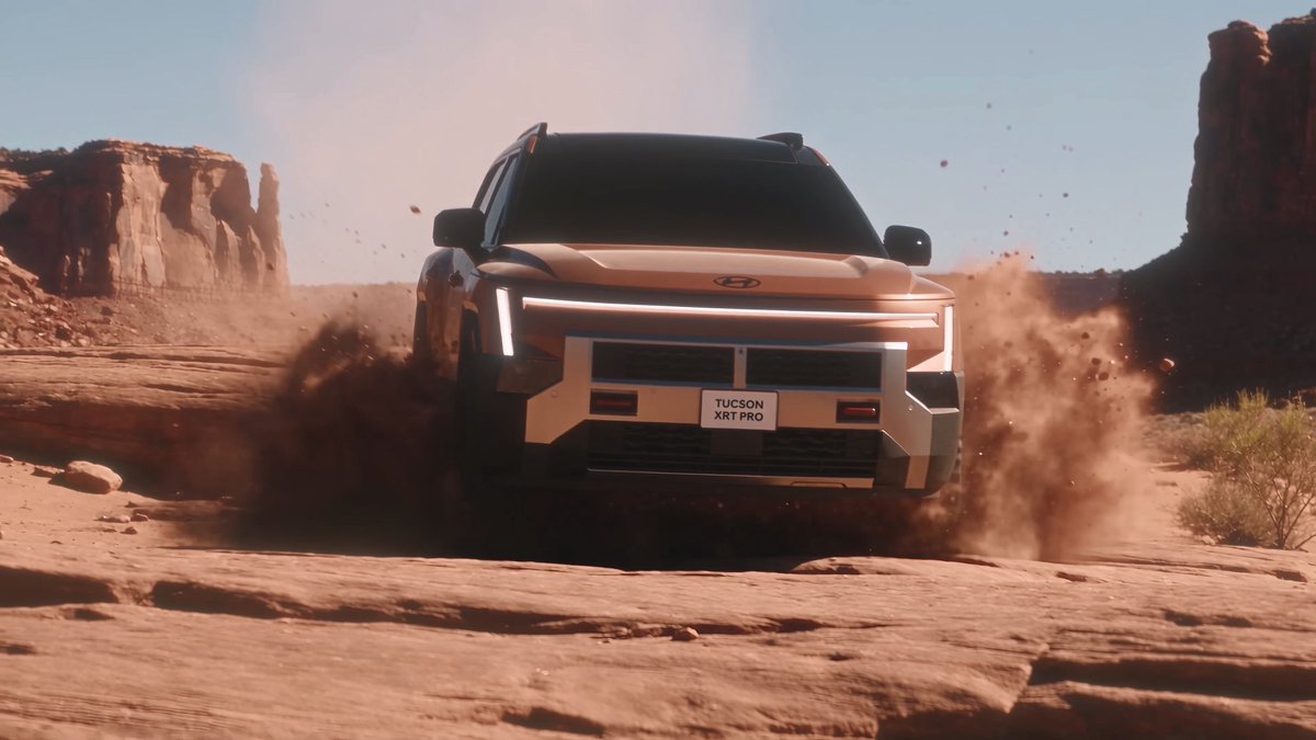A promotional image shows a white Hyundai Tucson XRT PRO SUV driving aggressively through a dusty desert landscape with red rock cliffs, creating large dust clouds around the vehicle.