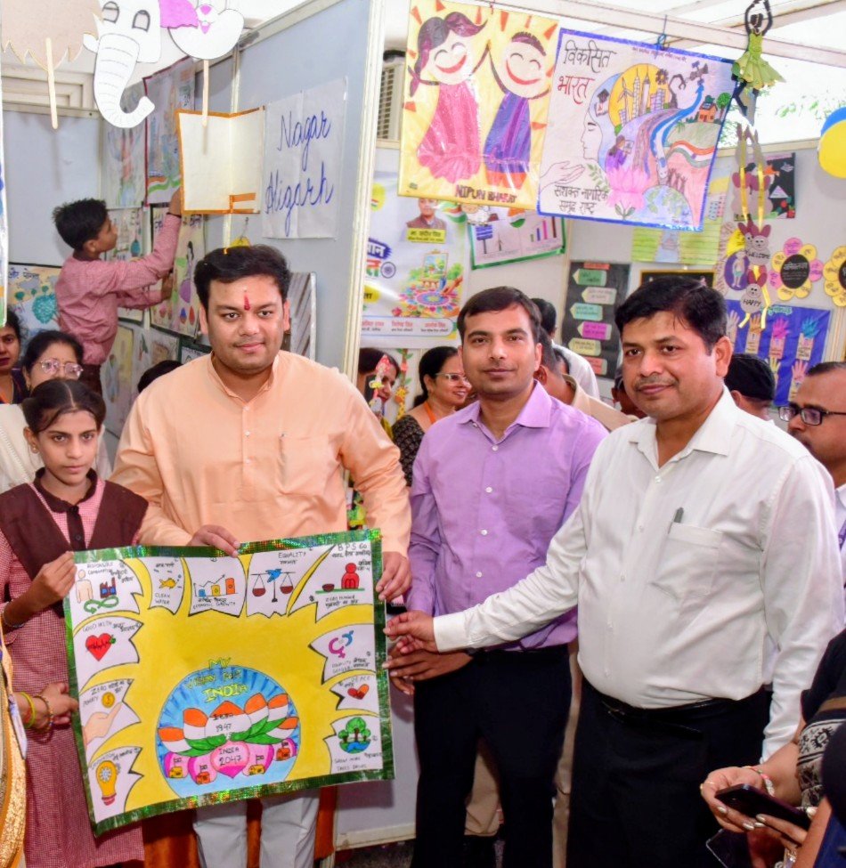 basicshiksha_up's tweet photo. रंगों, रचनात्मकता और सीख से सजा विकसित भारत का संकल्प 

सेवा संकल्प अभियान के अंतर्गत अलीगढ़ के कल्याण सिंह हेबिटेट सेंटर में जनपद स्तरीय ड्रॉइंग-पेंटिंग प्रतियोगिता एवं TLM प्रदर्शनी आयोजित की गई। बेसिक शिक्षा मंत्री (स्वतंत्र प्रभार) श्री संदीप सिंह जी ने प्रदर्शनी का शुभारंभ कर विद्यार्थियों एवं शिक्षकों के स्टॉलों का अवलोकन किया।

विद्यार्थियों की कलाकृतियों और TLM में रचनात्मकता, संस्कार, वैज्ञानिक सोच एवं विकसित भारत की परिकल्पना की सुंदर झलक दिखाई दी। चयनित विद्यार्थियों को प्रशस्ति-पत्र एवं स्टेशनरी प्रदान कर उनका उत्साहवर्धन किया गया।

बेसिक शिक्षा विभाग, उत्तर प्रदेश बच्चों की प्रतिभा और सृजनशीलता को मंच देते हुए शिक्षा को संस्कार, नवाचार और राष्ट्र निर्माण से जोड़ने के लिए निरंतर प्रयासरत है।

#SchoolEducation #SamagraShiksha
 #25CroreBachchonKeSapnoKaBharat
 #SchoolsForViksitBharat 
#SevaSankalpAbhiyan
#MereSapnoKaBharat