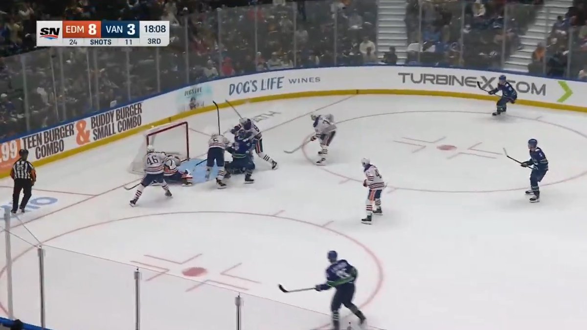 A hockey game between EDM and VAN showing a score of EDM 8 to VAN 3 at 18:08 in the 3rd period, with players gathered near the goal during the broadcast on SN.
