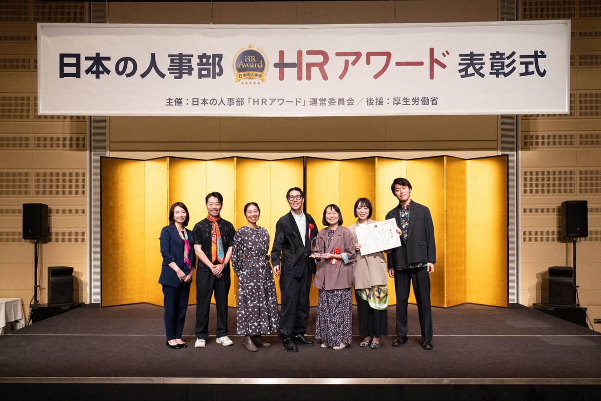 heralbony_twins's tweet photo. 【HRアワード｜HERALBONY ACADEMY最優秀賞👑】

人事が選ぶ最高の栄誉であるHRアワードをヘラルボニーの研修事業が最優秀賞を受賞しました！！

人類の進化とは、何だろう。

より速く移動できること。
より多く生産できること。
より高い能力を持つこと。
より便利になること。

もちろん、それも進化なのだと思います。でも、もうひとつの進化があるのではないでしょうか。

より多くちがいを肯定できること。

2018年の創業以来、私たちは何度も「障害のある人を救っていてすごいですね」と言われてきました。

でも、ヘラルボニーは誰かを救うためだけに存在している会社ではなく、むしろ、私たち自身が何度も世界の見方を当事者に変えてもらってきました。

むしろ、私たちが「当たり前」だと思っていた世界の狭さに気づかせてくれるものです。

今回、HRアワードという形でこの挑戦が評価されたことを、心から嬉しく思います。

「違いは、克服されるものではなく、未来をつくる力になり得る」そんな価値観が、社会に認められ始めた小さな証明なのかもしれません。

人類が次に進化するとしたら、テクノロジーだけではなく、人間を見る私たちの眼差しそのものなのだと思います。

この受賞を、その未来への一歩として受け取りたいと思います。

「ヘラルボニー＝アート」のイメージが強いですが、実は大きく育ってきているこの事業。

ぜひ、この研修プログラムを社会にもっと開いていきたいので、興味のある方、ご連絡ください。

あらためて、ヘラルボニーのウェルフェアチームに拍手をしたいです、おめでとう👏㊗️

◉HERALBONY ACADEMY
https://t.co/fplkXTDvXJ

◉最高評価ー体験型DE&I研修プログラム『HERALBONY ACADEMY』が「ＨＲアワード2026」プロフェッショナル人材開発・育成部門で最優秀賞を受賞
https://t.co/6aWU4DC2NN