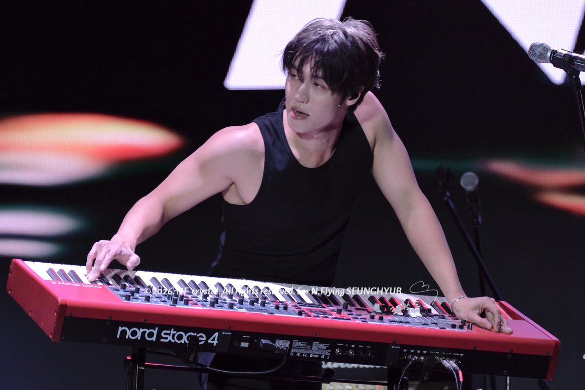 A musician in a black tank top plays a red 'nord stage 4' keyboard on stage, with text crediting 'All Rights Reserved For N.Flying SEUNGCHYUB'.