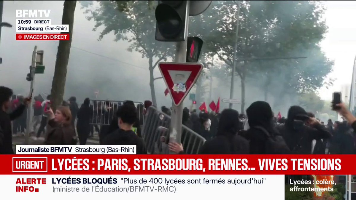A BFMTV live news broadcast shows a tense protest in Strasbourg, France, with smoke and crowds behind police barricades, accompanied by the urgent headline 'LYCÉES : PARIS, STRASBOURG, RENNES... VIVES TENSIONS' regarding blocked schools.