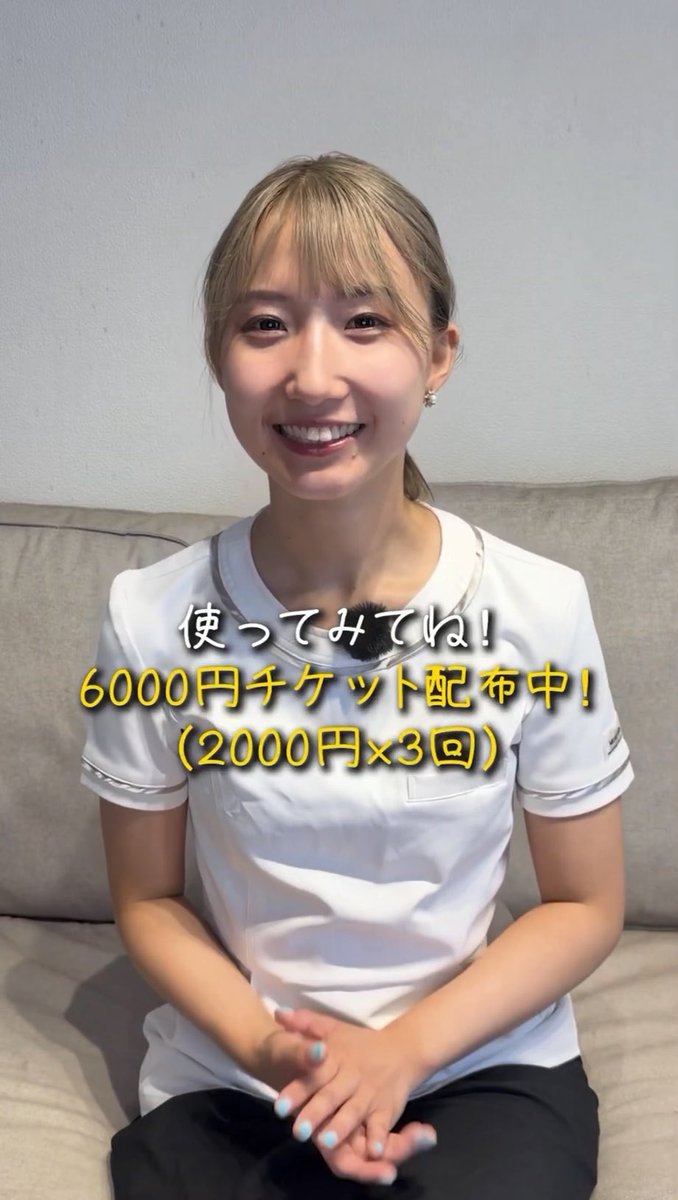 A smiling young woman with blonde bangs, wearing a white uniform top, sits on a beige sofa; overlaid Japanese text reads "使ってみてね！6000円チケット配布中！（2000円×3回）".