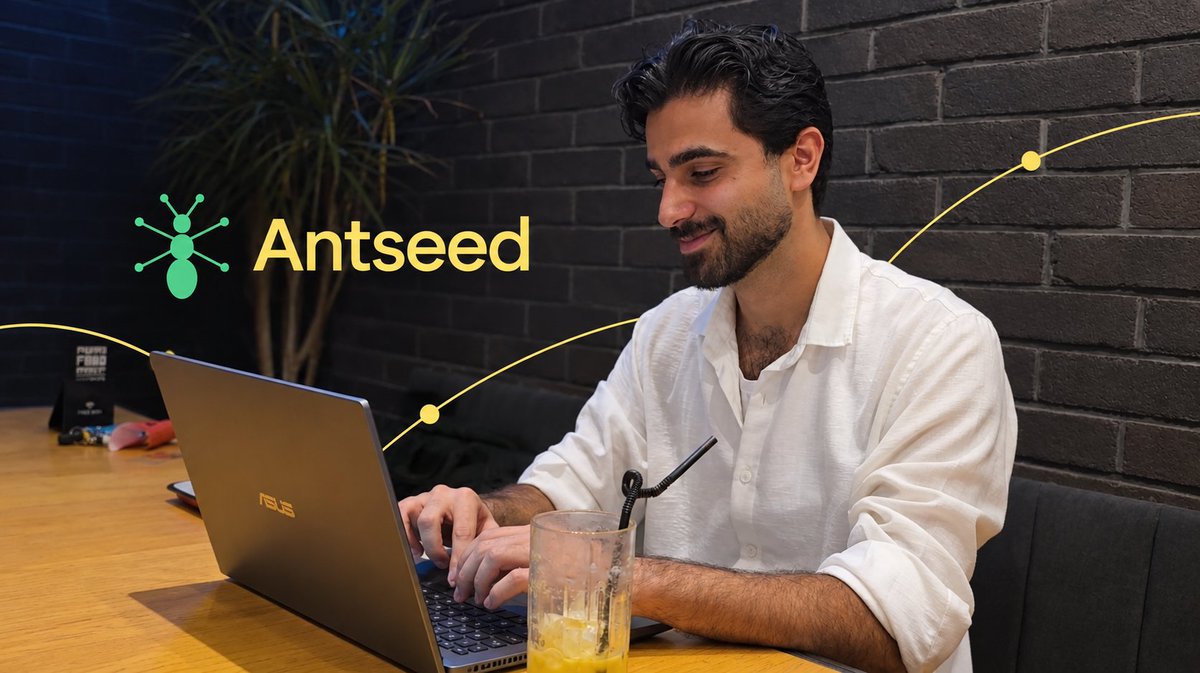 A man in a white shirt works on an ASUS laptop in a modern interior, with an 'Antseed' logo featuring an ant icon overlaid on the image.