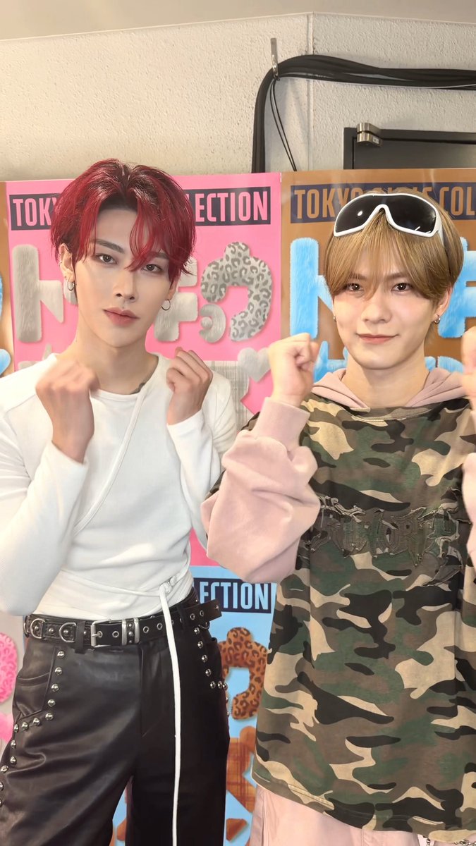Two young men pose for a photo with their fists raised in front of colorful 'Tokyo Collection' backdrops.