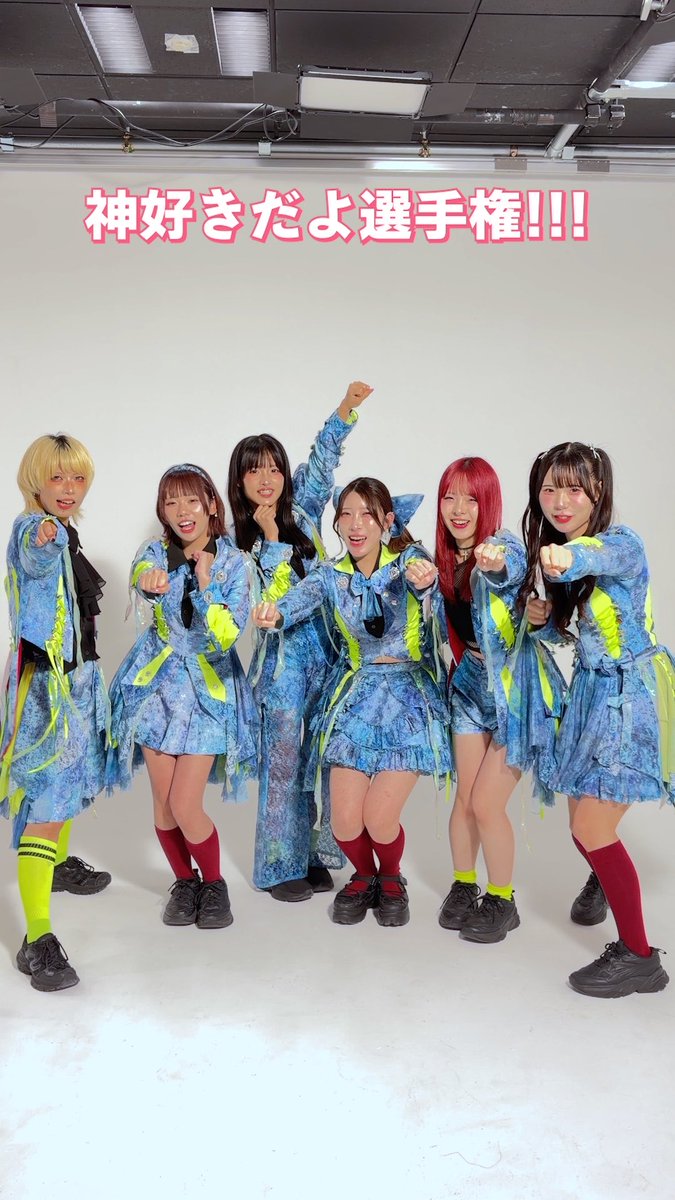 Six women in coordinated blue and neon green outfits pose energetically together with text overlay reading "神好きだよ選手権!!!" (Kami-suki da yo Senshuken!!!).