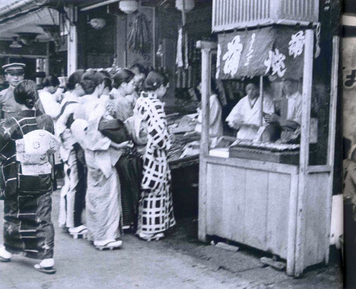 5Te6IA0NzW6JEYj's tweet photo. 昭和14年（1939年）の新宿、鰻のかば焼きの屋台に並ぶ女性たちです。こりゃ並びますよね。 https://t.co/pQVYEXJhcX