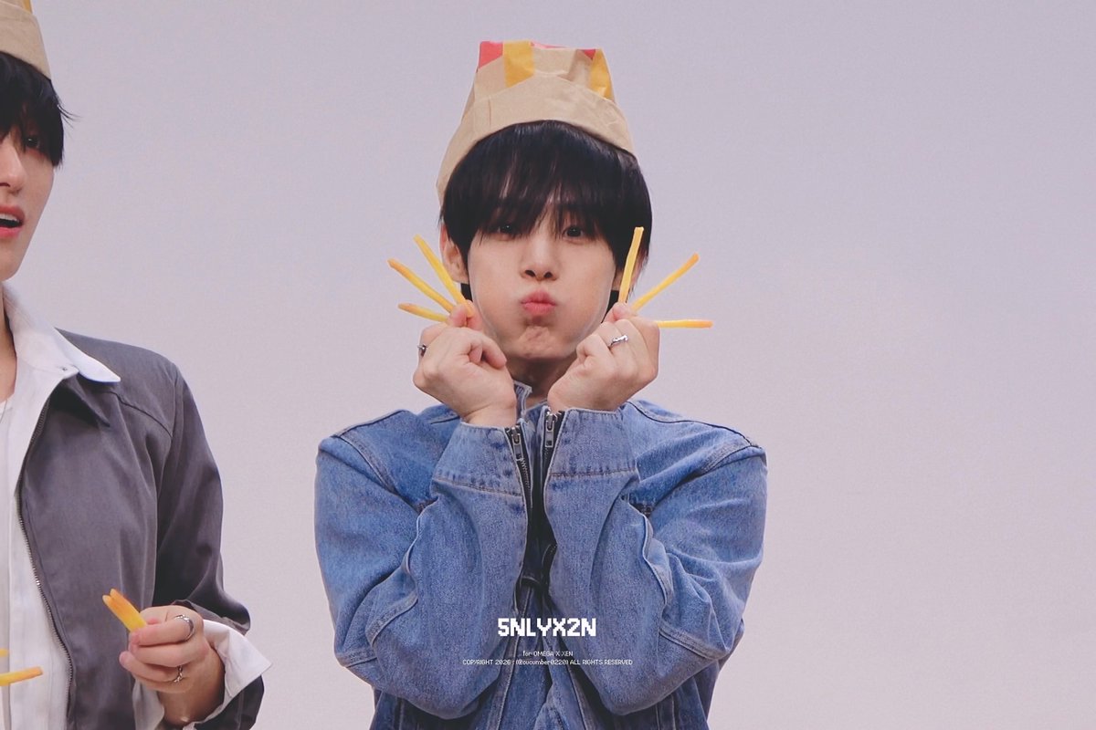 A promotional photo of a K-pop idol (onlyx2n) wearing a denim jacket and a McDonald's-style paper hat, holding French fries near his face with a pouting expression, with the text 'ONLYX2N' and 'COPYRIGHT 2025 (B)beoncompany'.
