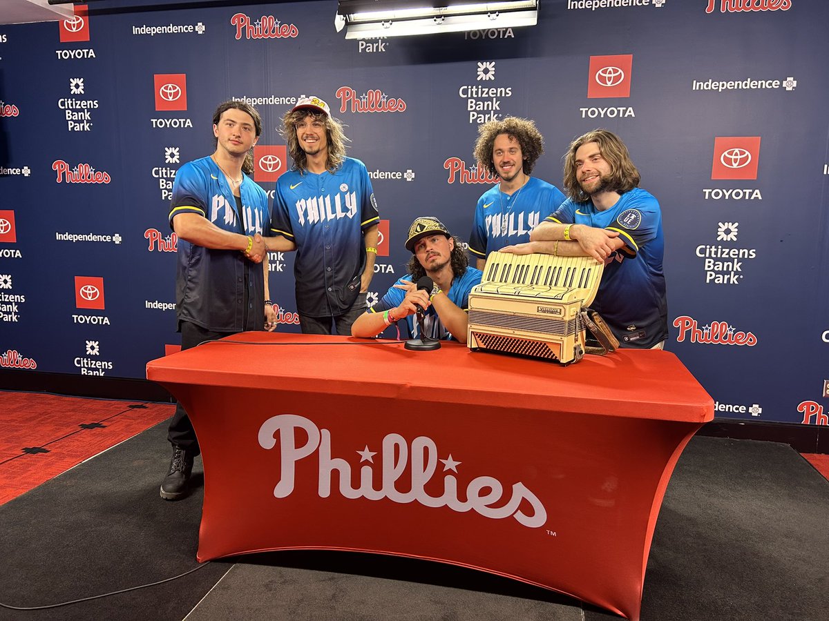 dogsinapileband's tweet photo. Back in the City of Brotherly Love in 7️⃣ days!
Well, just outside of it in King Of Prussia 🦎
This is probably the only photo you’ll ever see of Jimmy wearing a @phillies jersey, so enjoy it ⚾️
Tix available on our website 🎟️
#DogPound🐶 https://t.co/SLbv2Pxesu