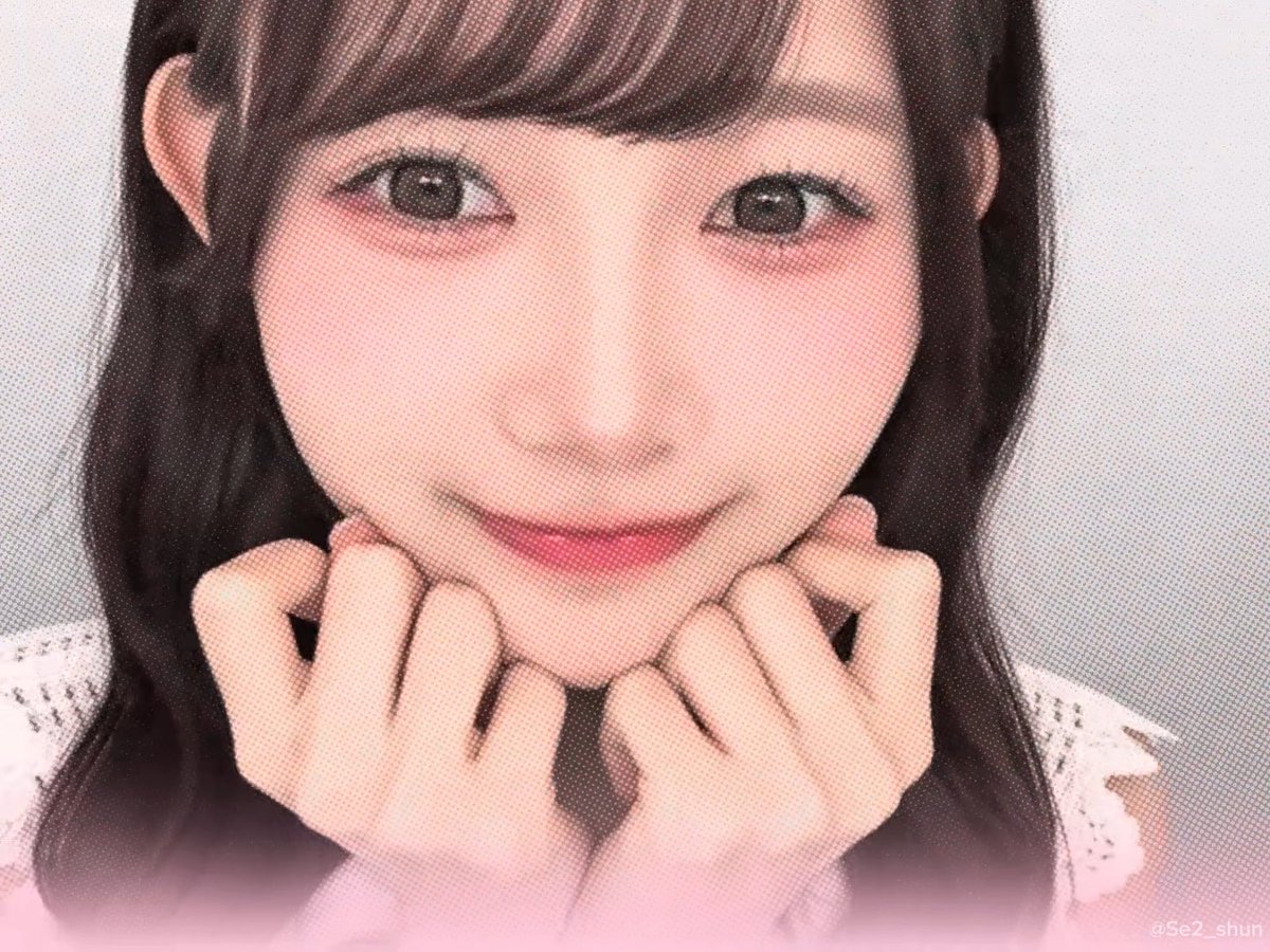 A close-up portrait of a smiling young woman with dark hair and bangs, posing with her hands under her chin, signed '@Se2_shun' in the corner.