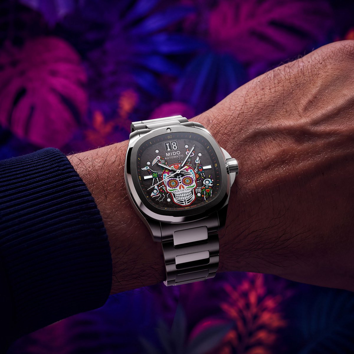 aBlogtoWatch's tweet photo. The new Multifort TV Big Date Día de los Muertos Alebrijes introduces its colorful calavera motif to the retro-inspired Multifort TV collection for the first time, bringing a distinctly Mexican character to one of the brand’s most recognizable contemporary designs.

Observed on November 1 and 2, Día de los Muertos, or Day of the Dead, is a Mexican holiday honoring deceased loved ones through colorful celebrations rooted in Indigenous and Catholic traditions. Families create ofrendas, or altars, decorated with photographs, marigolds, candles, and offerings to welcome the spirits of the departed. UNESCO recognized the tradition as Intangible Cultural Heritage in 2008.

The centerpiece of the Multifort TV Big Date Día de los Muertos Alebrijes is its elaborate gray-to-black gradient dial. A colorful calavera occupies the center of the composition, surrounded by fantastical animal figures inspired by Mexican alebrijes. Twelve different lacquers create the intricate multicolored artwork, while animal motifs engraved in negative relief introduce additional texture and depth with the addition of three colors of Swiss Super-LumiNova, taking on a different appearance in the dark. 

The oversized date display remains positioned at 12 o’clock, powered by Mido’s automatic Caliber 90 based on the ETA C07.651. Recessed luminous hour markers and diamond-cut, faceted hands provide the essential timekeeping indications. Even the date mechanism receives a thematic detail: the numeral 1 is shaped like a bone, carrying the Día de los Muertos inspiration into one of the watch’s defining mechanical features.

With its combination of traditional cultural imagery, vibrant dial decoration, and the contemporary Multifort TV case, the Día de los Muertos Alebrijes continues a tradition that has become a distinctive part of Mido’s annual collection.

Discover the Mido Multifort TV Big Date Día de los Muertos Alebrijes now on aBlogtoWatch.

#SponsoredPost
