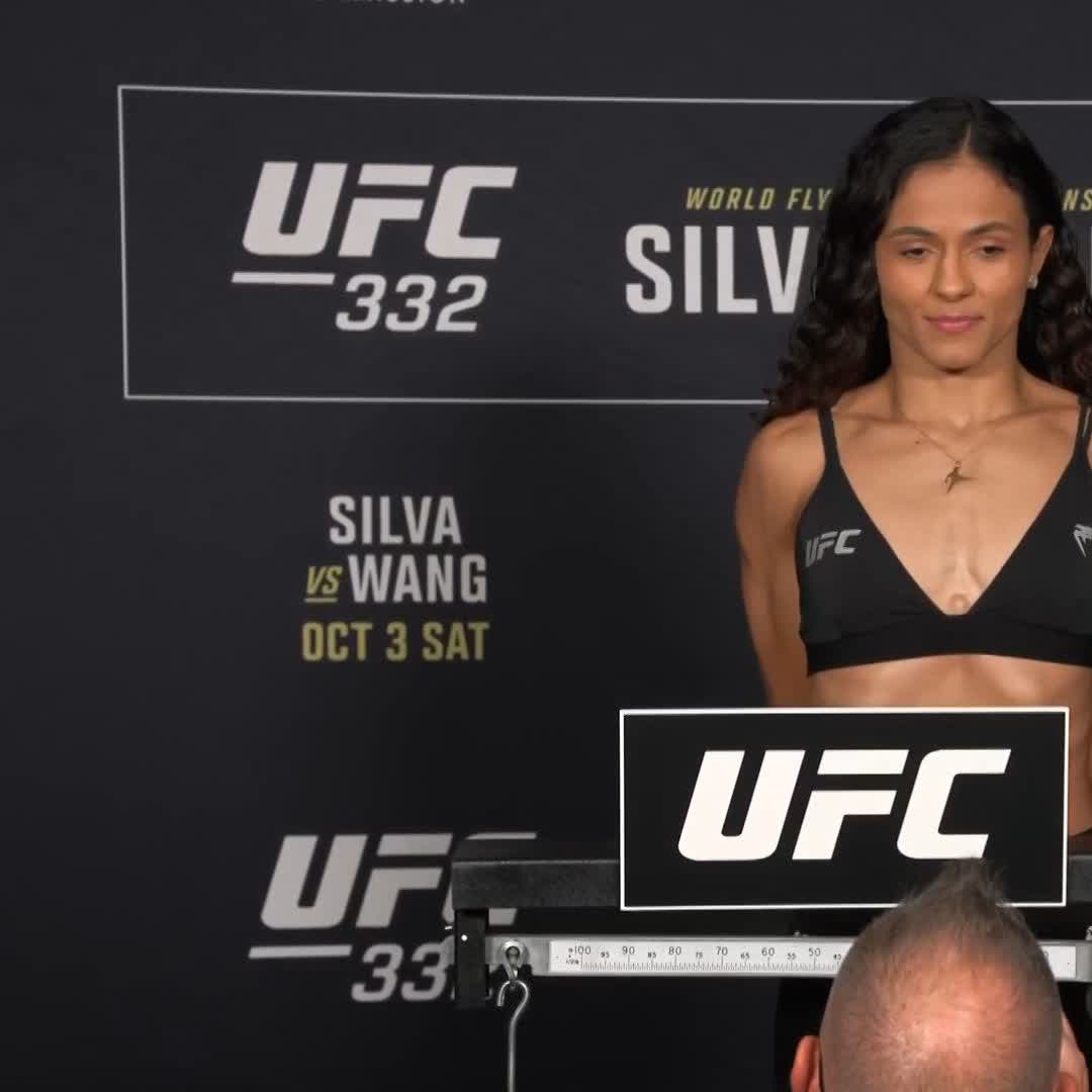 A female UFC fighter stands on a scale during the official weigh-in for UFC 332, with the backdrop promoting the "Silva vs Wang" main event scheduled for "Oct 3 Sat." The image aligns with the post, showing Natalia Silva preparing for tomorrow's flyweight title fight after weighing in at 125 lbs (56.7 kg).