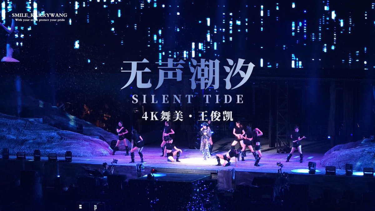 A concert stage scene with performers, displaying large Chinese text '无声潮汐' and 'SILENT TIDE' along with '4K舞美 · 王俊凯', indicating a performance by Wang Junkai.