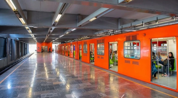 A bright orange Line B Mexico City Metro train sits with open doors at the Tepito station platform, unrelated to the reported track incident.