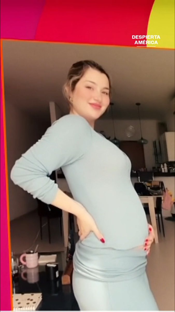 A pregnant woman in a light blue dress poses indoors, smiling with her hands on her hips, while the text "DESPIERTA AMÉRICA" appears in the top right corner.