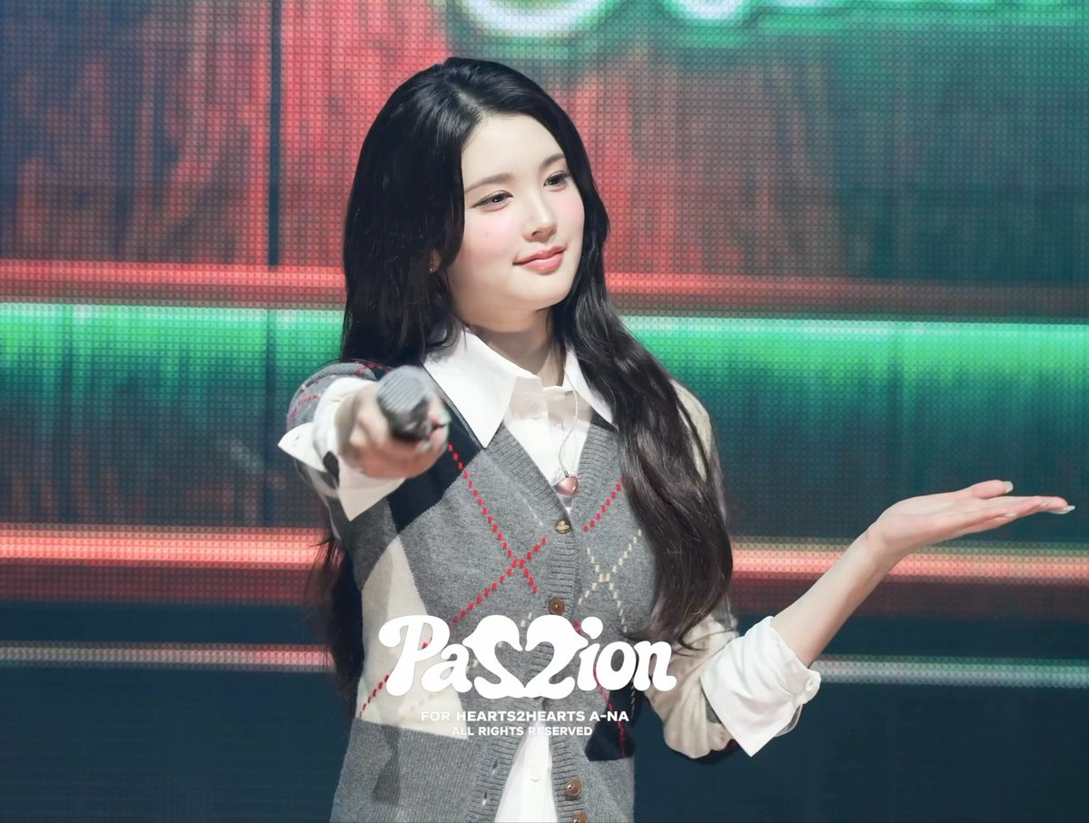 A performer named A-na waves and points a microphone toward the camera, with a logo reading 'PaS2ion FOR HEARTS2HEARTS A-NA ALL RIGHTS RESERVED' overlaid on a colorful stage background.
