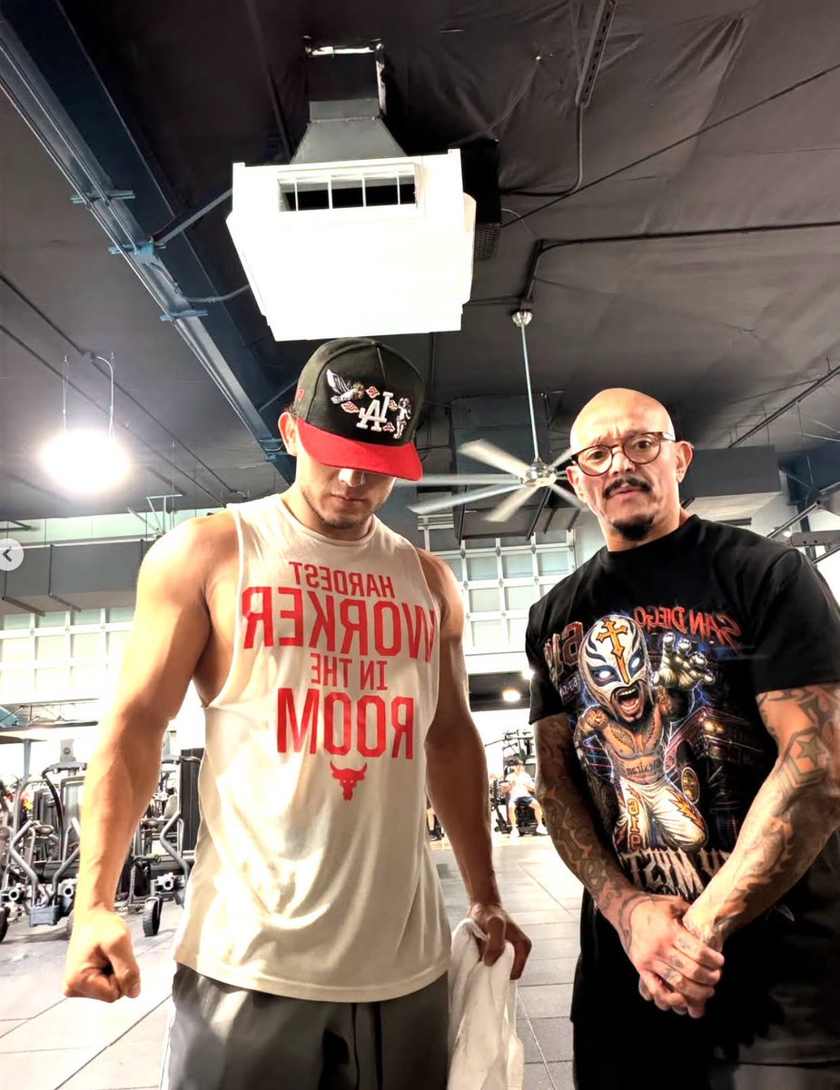 Complex's tweet photo. Rey Mysterio without his mask still feels illegal. 

Dragon Lee posted a photo of the WWE legend completely unmasked on IG, wearing glasses and a Mysterio shirt while posing together at a gym. https://t.co/0msS8Rucec