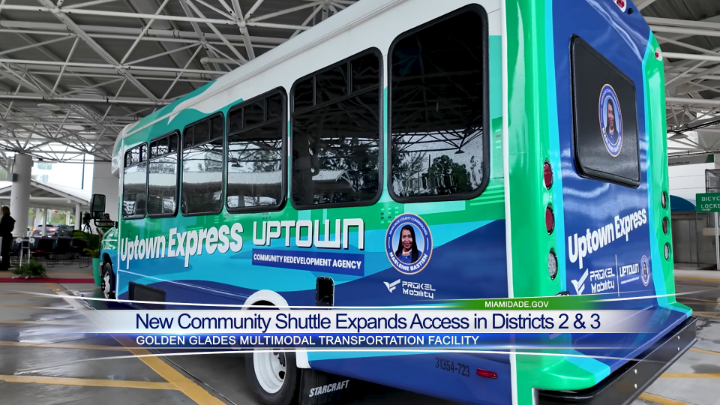 A green, white, and blue 'Uptown Express' community shuttle bus from Miami Dade is shown, with text announcing 'New Community Shuttle Expands Access in Districts 2 & 3' at the Golden Glades Multimodal Transportation Facility.