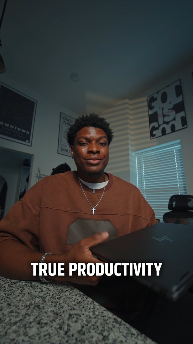 A young man sits at a desk with a laptop in a stylish room featuring framed wall art, with the text "TRUE PRODUCTIVITY" overlaid across the image—visually reinforcing the post's message about developers needing powerful Ryzen AI hardware to stop redoing work and instead leverage AI assistance for faster, smarter coding.